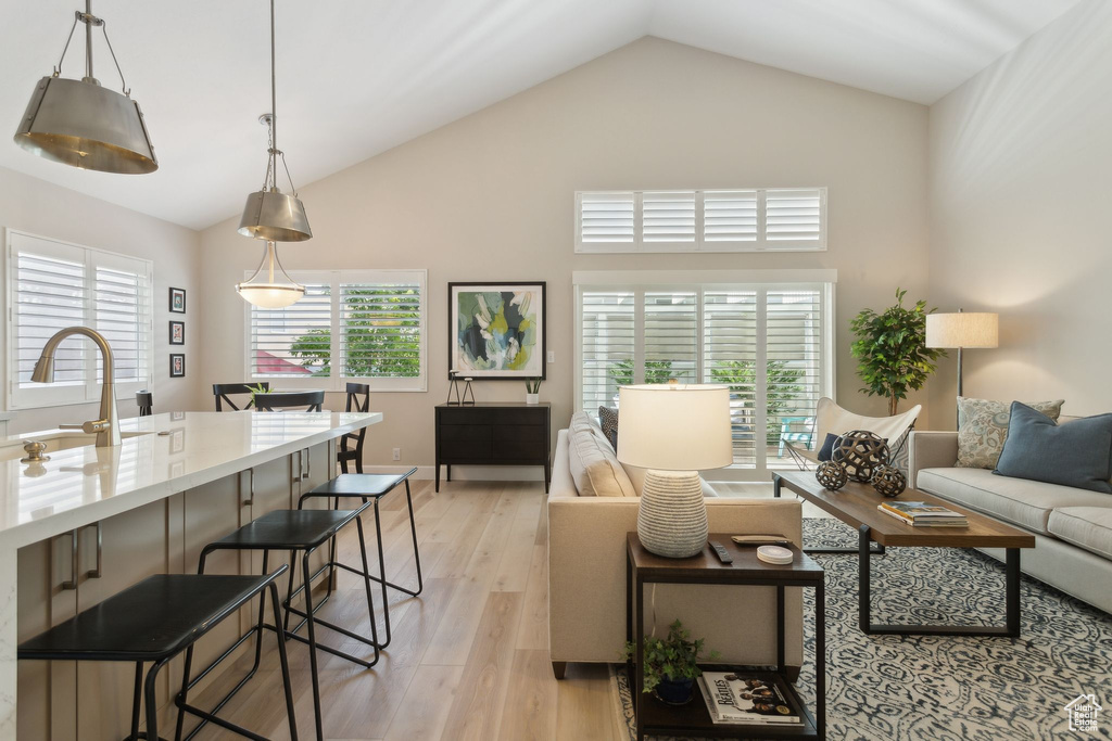 Living area featuring light wood-style floors and high vaulted ceiling
