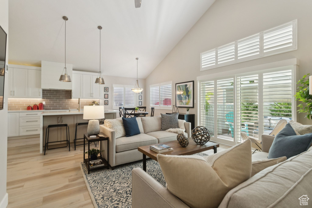 Living area with high vaulted ceiling and light wood finished floors