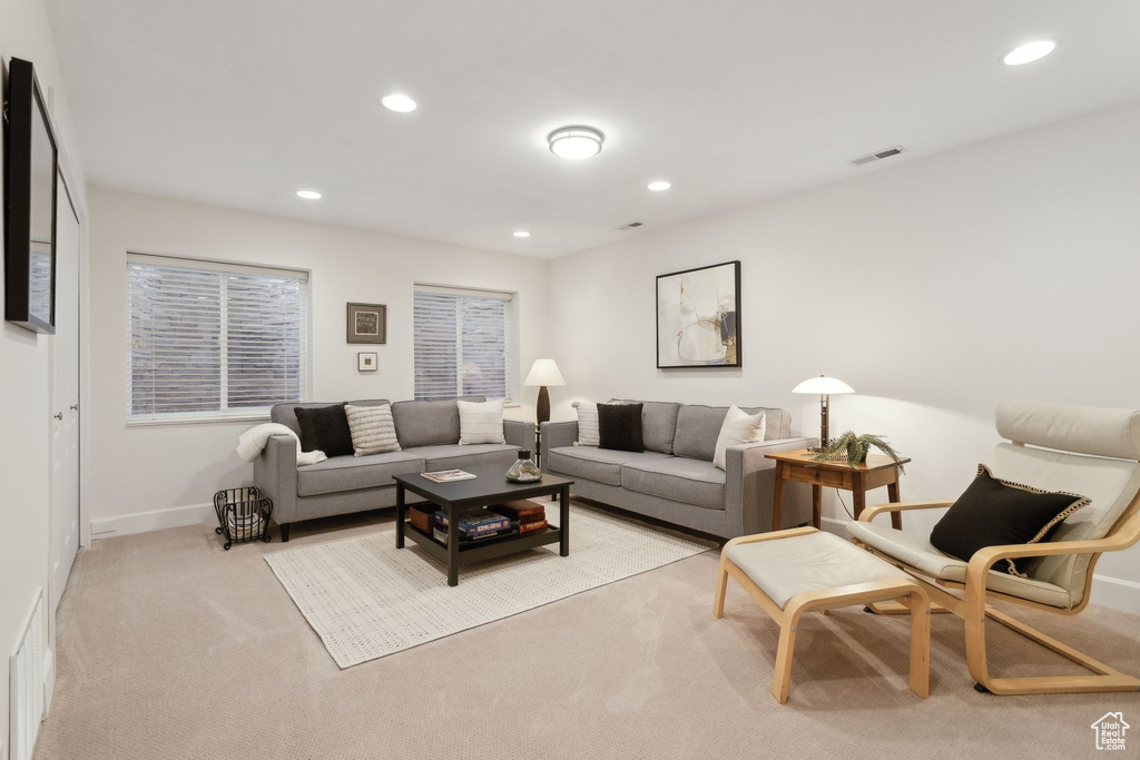 Living area featuring recessed lighting, baseboards, and light carpet