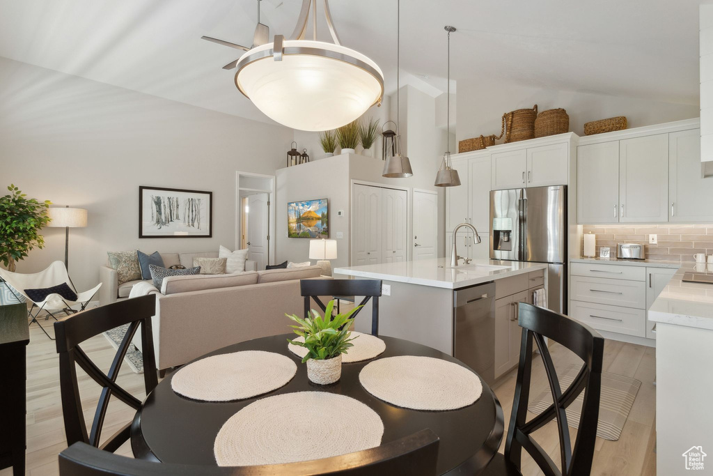Dining area with light wood finished floors and vaulted ceiling
