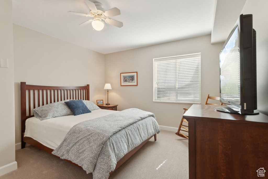 Carpeted bedroom featuring baseboards and ceiling fan