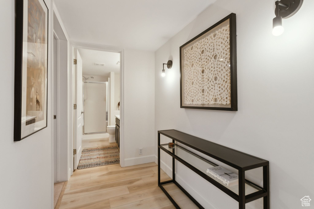 Hall featuring light wood-style flooring and baseboards