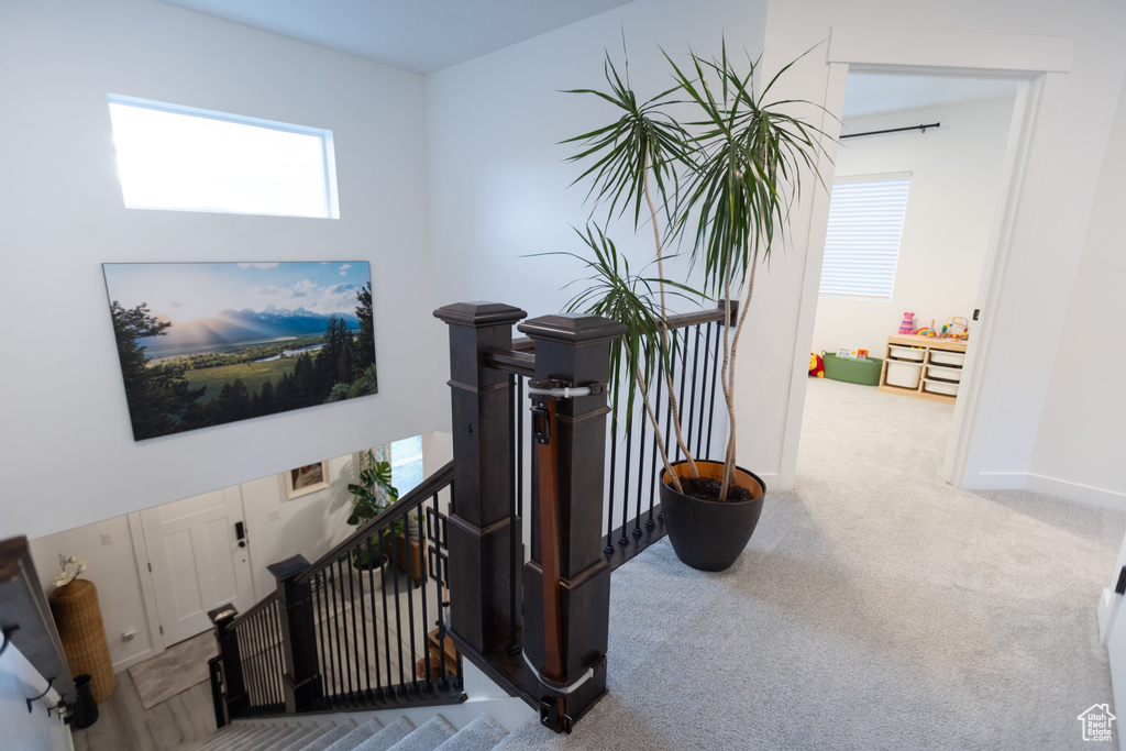 Hall featuring an upstairs landing, carpet flooring, and baseboards
