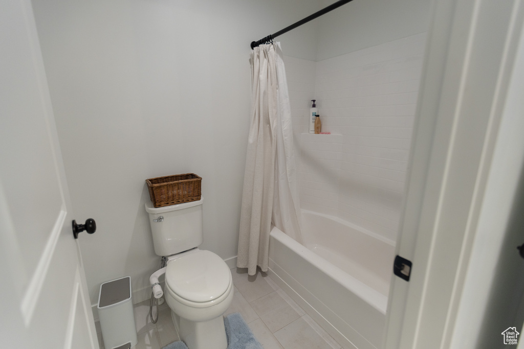 Bathroom featuring toilet, tile patterned flooring, and shower / tub combo