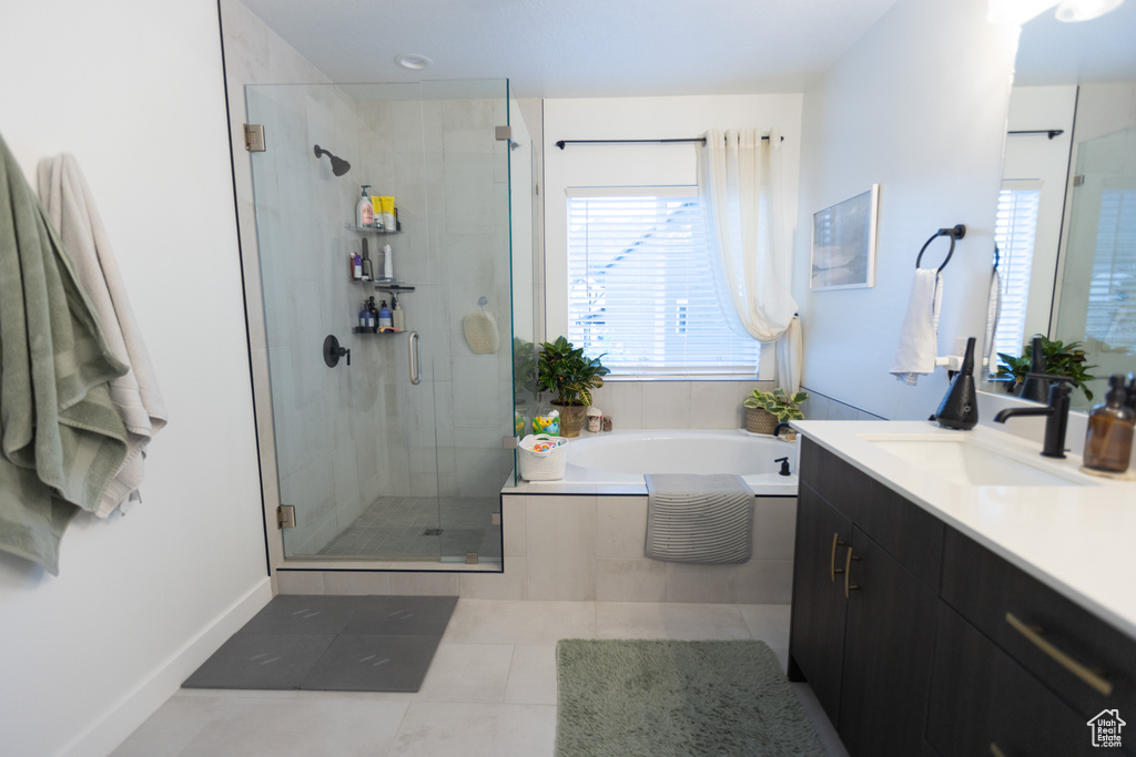 Bathroom with vanity, a stall shower, a garden tub, and tile patterned floors