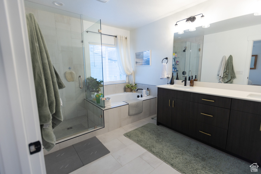 Bathroom with double vanity, a stall shower, and a garden tub