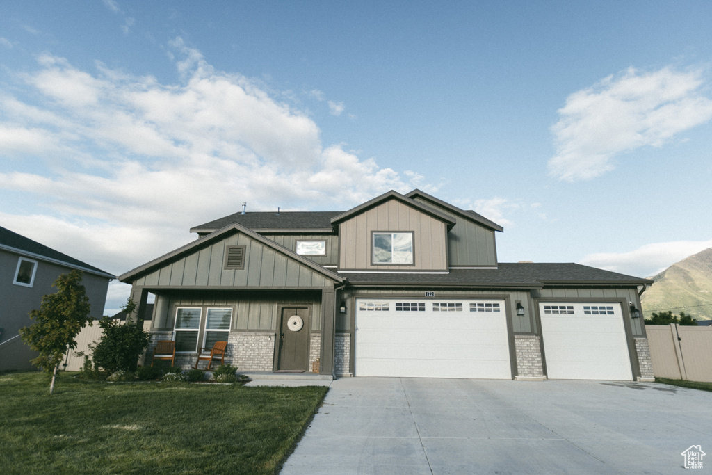 Craftsman house with concrete driveway, board and batten siding, brick siding, and a garage