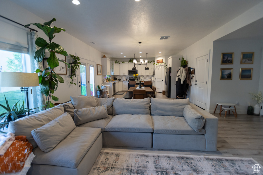 Living area featuring a chandelier, light wood finished floors, and recessed lighting
