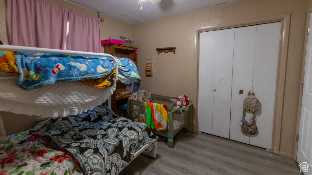 Bedroom featuring wood finished floors, a closet, and ceiling fan