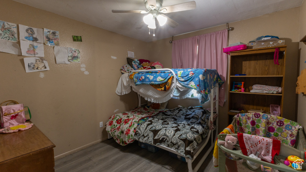 Bedroom featuring wood finished floors, baseboards, and a ceiling fan