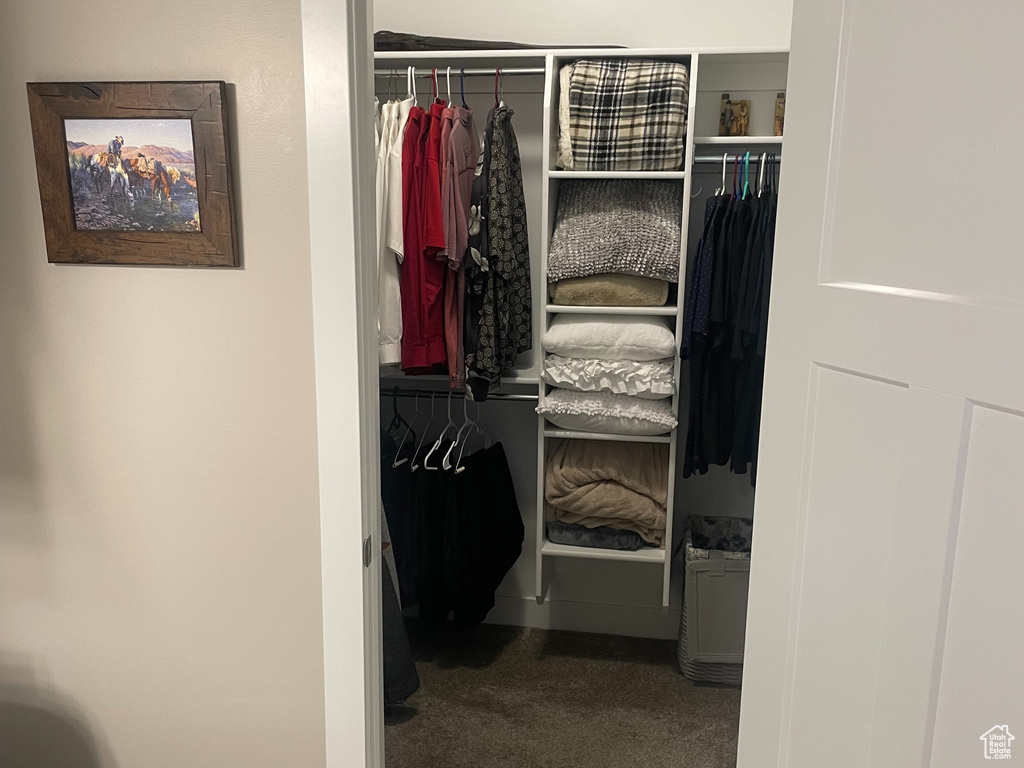 Bathroom featuring toilet, a spacious closet, tile patterned flooring, and baseboards