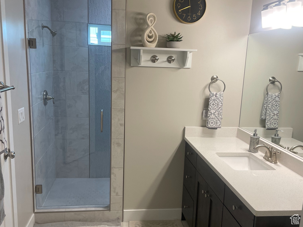 Full bath featuring a stall shower, vanity, baseboards, and tile patterned floors