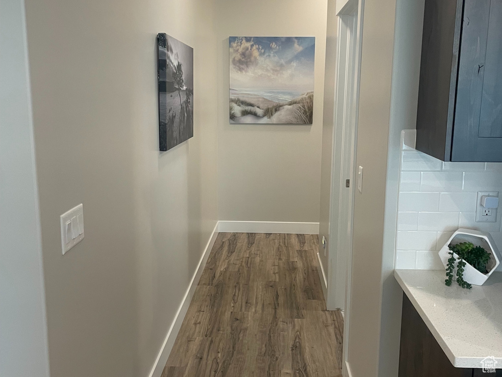 Corridor with dark wood-style flooring and baseboards