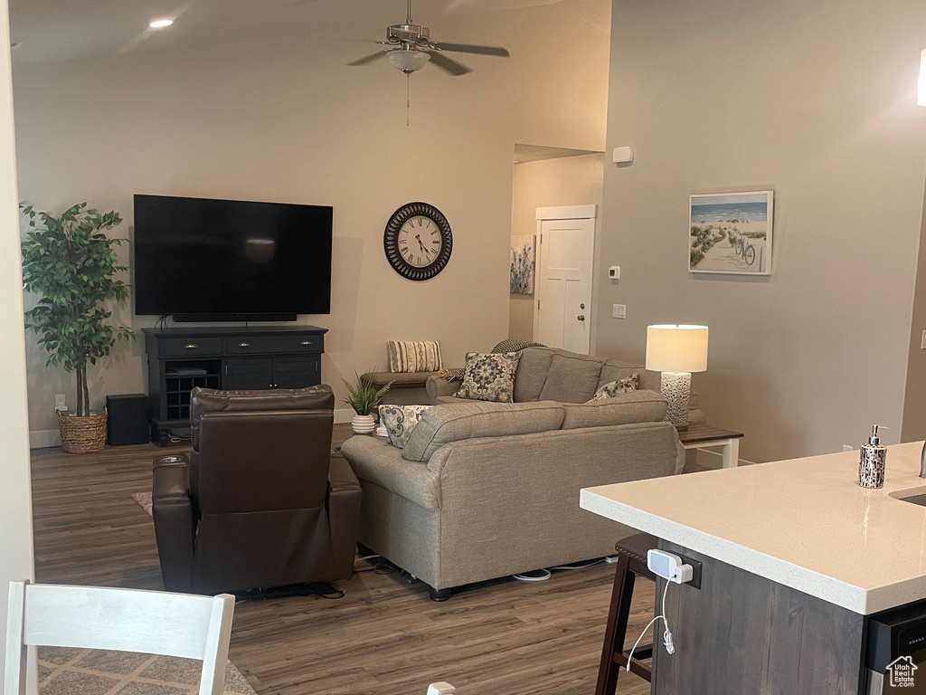 Living room featuring vaulted ceiling, a ceiling fan, wood finished floors, and recessed lighting
