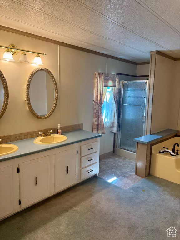 Full bath with a stall shower, double vanity, carpet floors, a textured ceiling, and ornamental molding