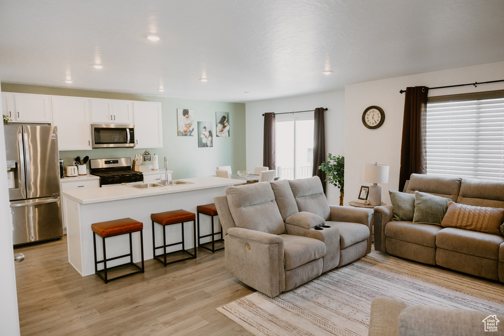 Living area with light wood finished floors and recessed lighting