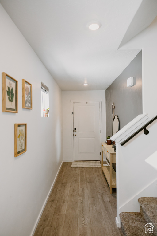 Entrance foyer featuring light wood-style floors, baseboards, and stairway