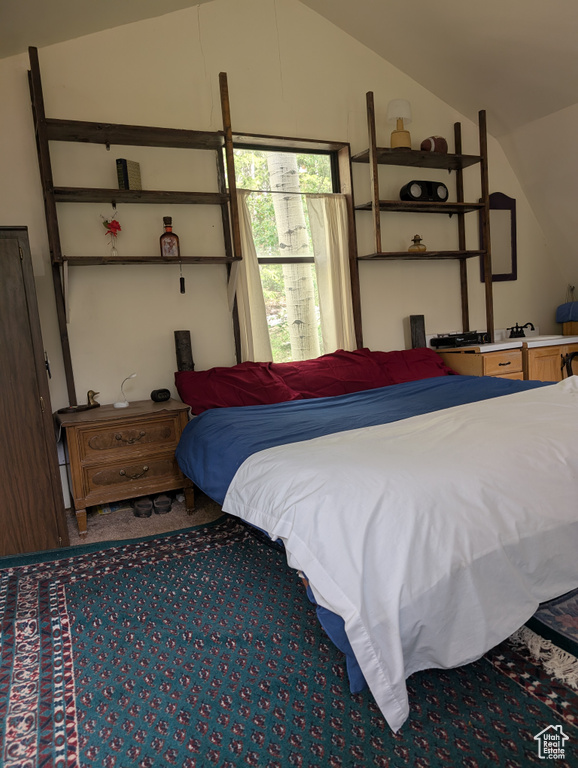 Carpeted bedroom with lofted ceiling