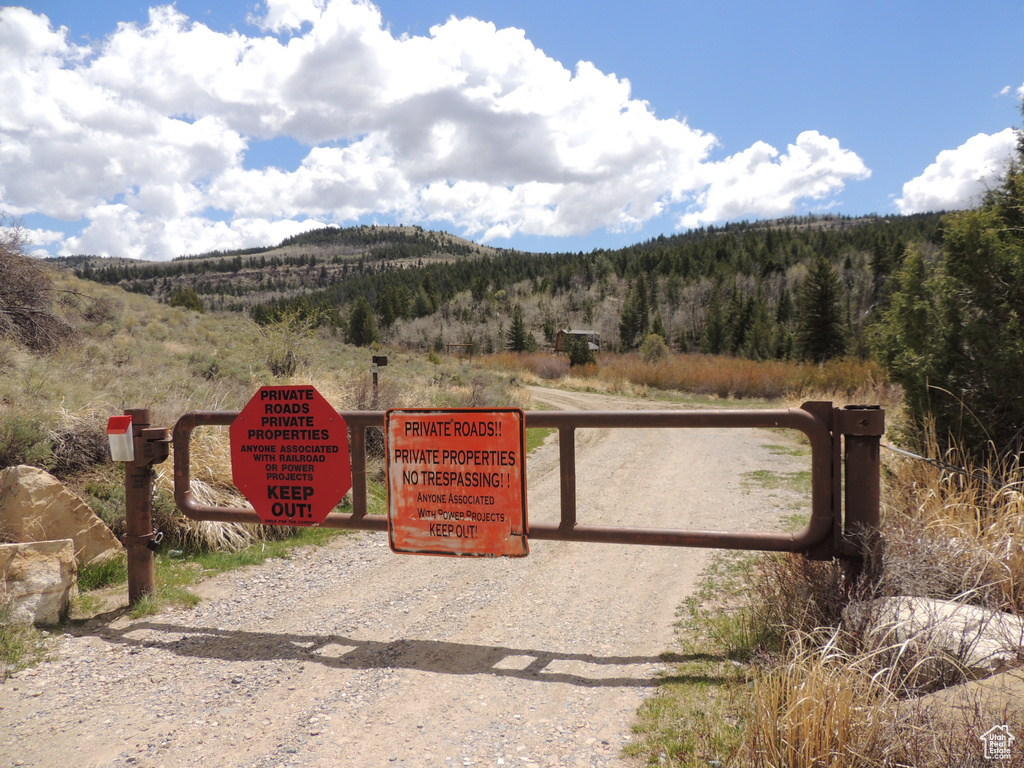 Gate featuring a mountain view and a wooded view