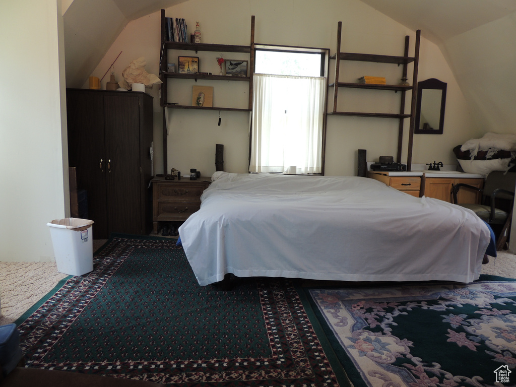 Bedroom with lofted ceiling and carpet floors