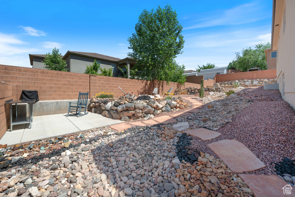 Fenced backyard featuring a patio and a fire pit