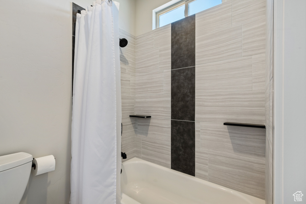 Full bathroom featuring shower / tub combo with curtain and toilet