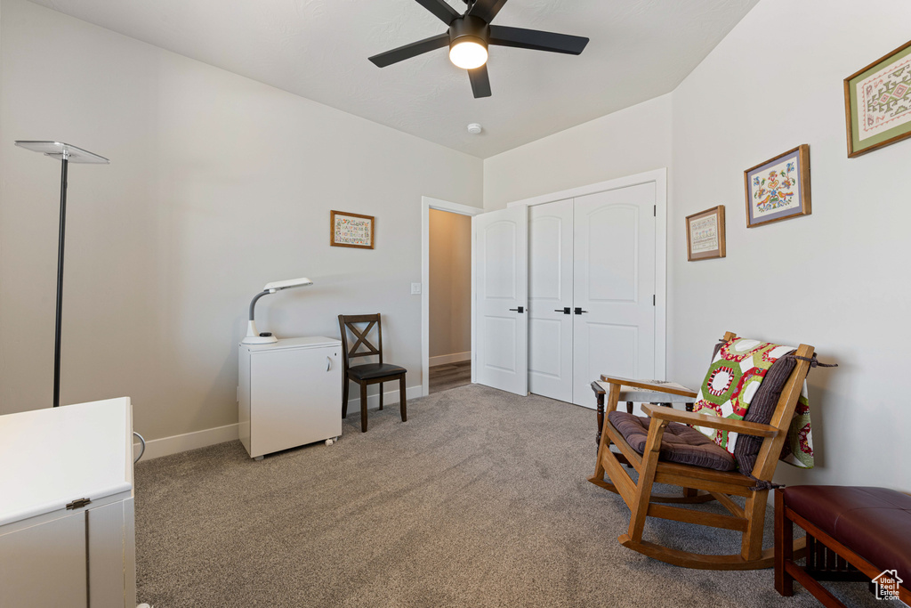 Sitting room with a ceiling fan, carpet flooring, and baseboards