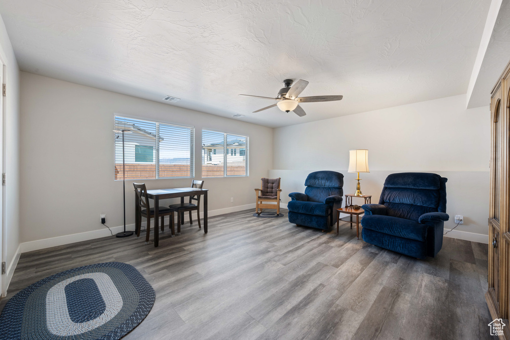 Living area featuring wood finished floors, baseboards, and a ceiling fan