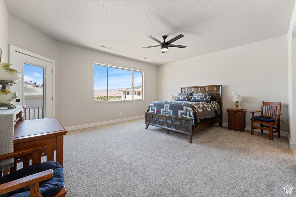 Carpeted bedroom with multiple windows, baseboards, and a ceiling fan