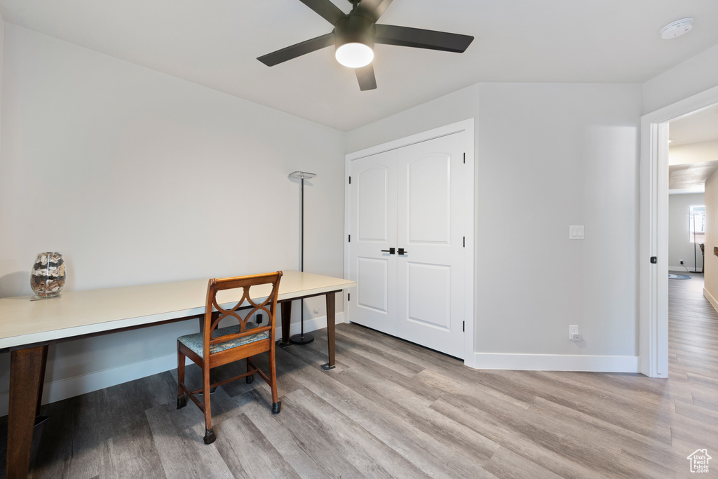 Home office with light wood-style flooring, ceiling fan, and baseboards
