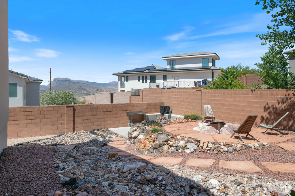 Back of house featuring a fire pit, a fenced backyard, and a mountain view
