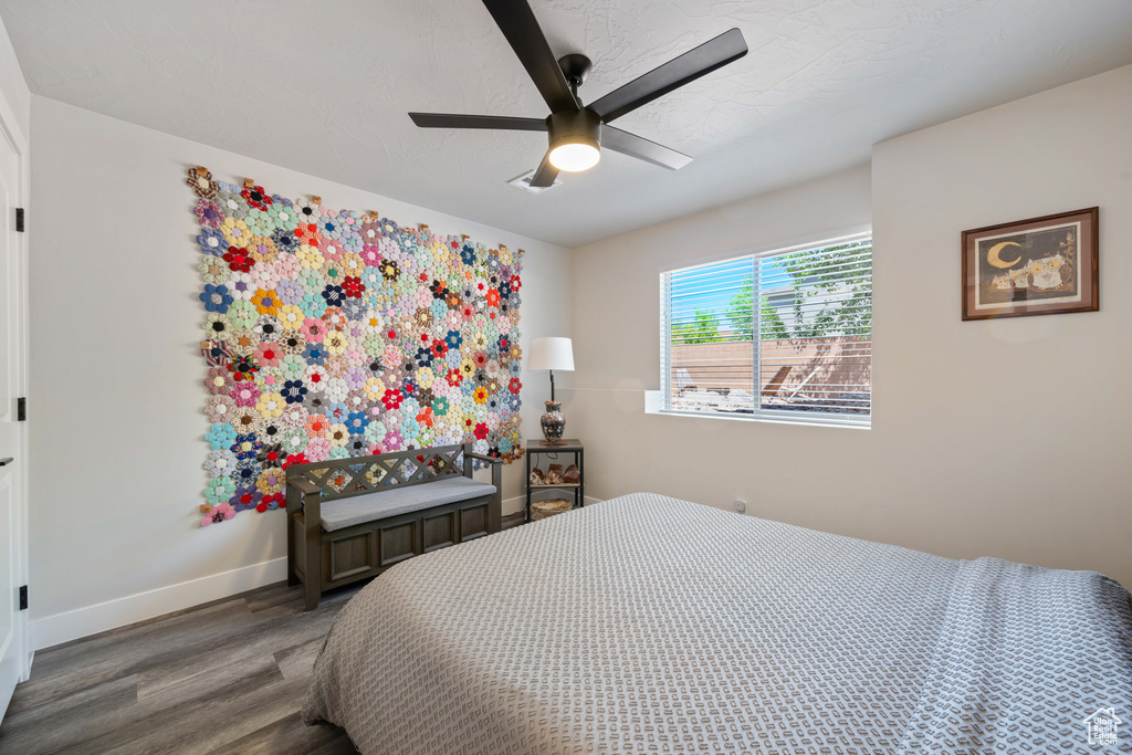 Bedroom with wood finished floors, baseboards, and ceiling fan