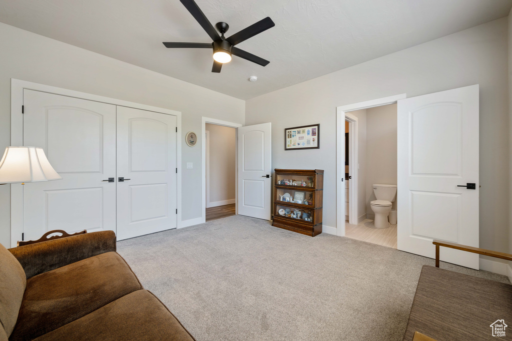 Sitting room featuring a ceiling fan, carpet floors, and baseboards