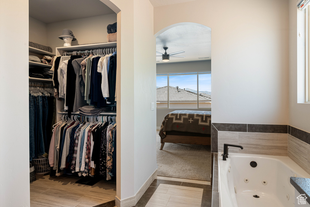 Walk in closet featuring arched walkways and a ceiling fan