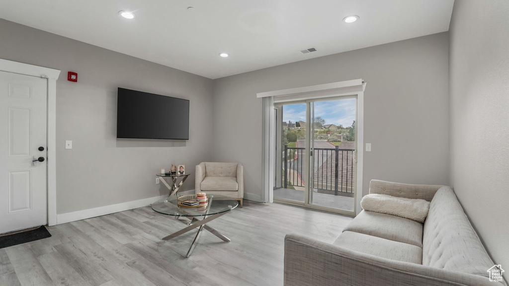 Living room featuring light wood-style floors, baseboards, and recessed lighting