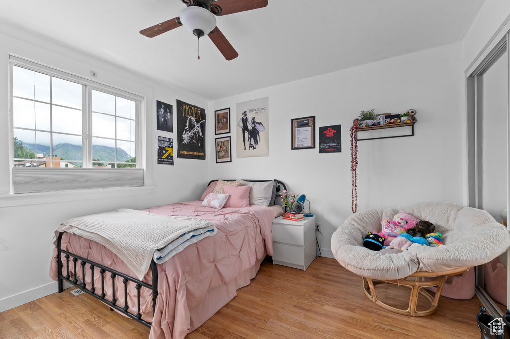 Bedroom featuring wood finished floors, baseboards, and ceiling fan