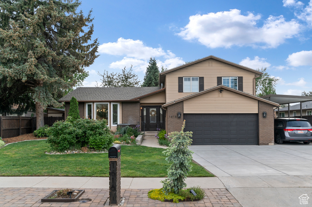 Tri-level home featuring brick siding, concrete driveway, and an attached garage