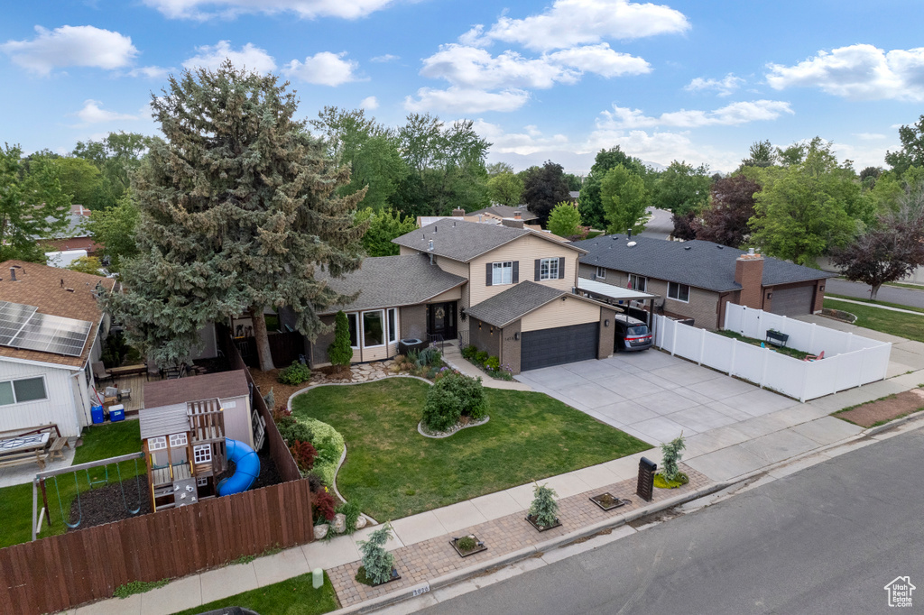 View of front facade featuring driveway, a garage, and a residential view