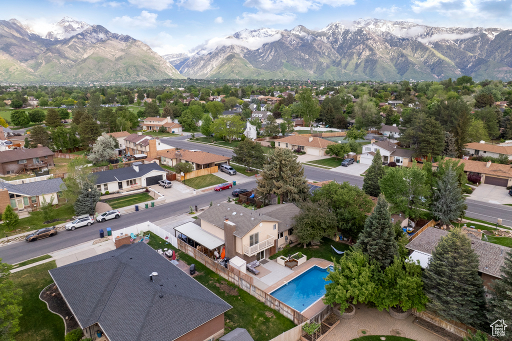 Aerial view of residential area featuring mountains and a pool area