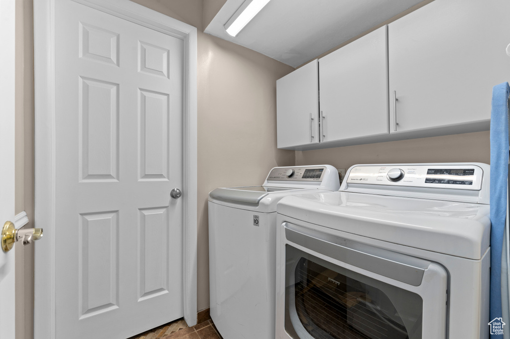 Laundry room with washer and clothes dryer and cabinet space