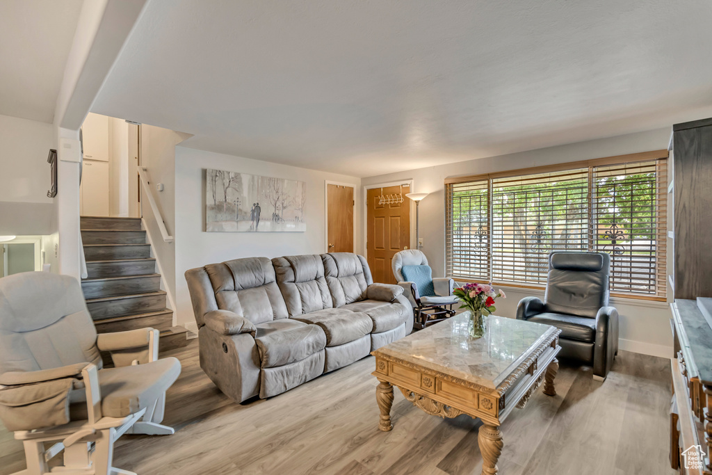 Living room with wood finished floors, stairs, and baseboards