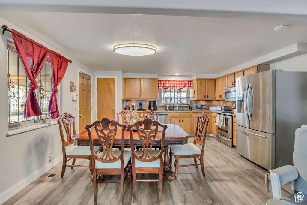 Dining space with light wood-type flooring and baseboards