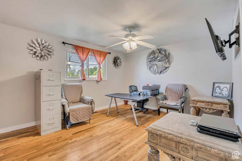 Home office featuring ceiling fan, light wood-type flooring, and baseboards