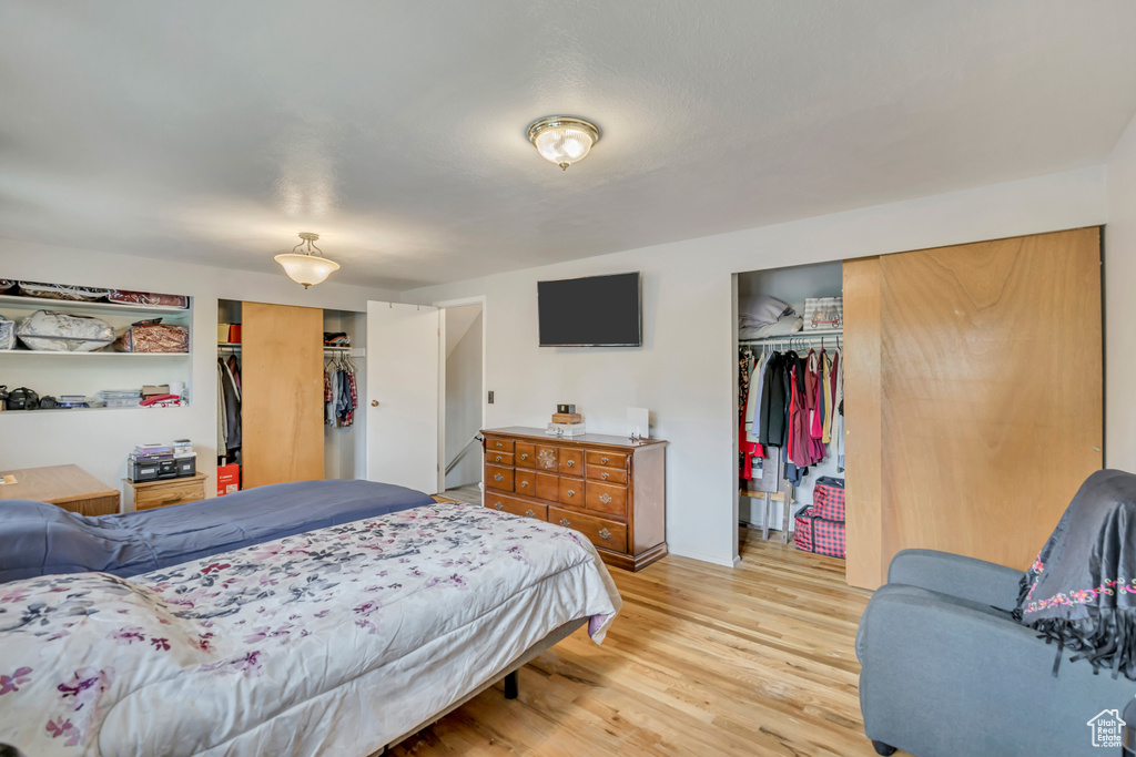 Bedroom with light wood-type flooring and multiple closets