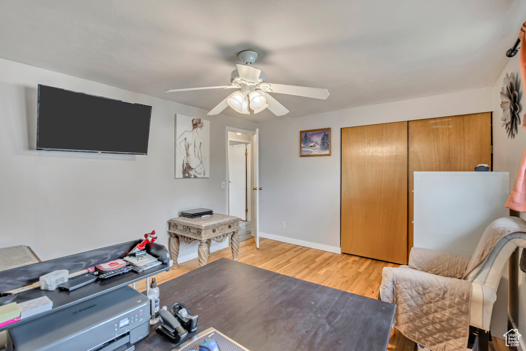 Office area featuring a ceiling fan, light wood-style floors, and baseboards