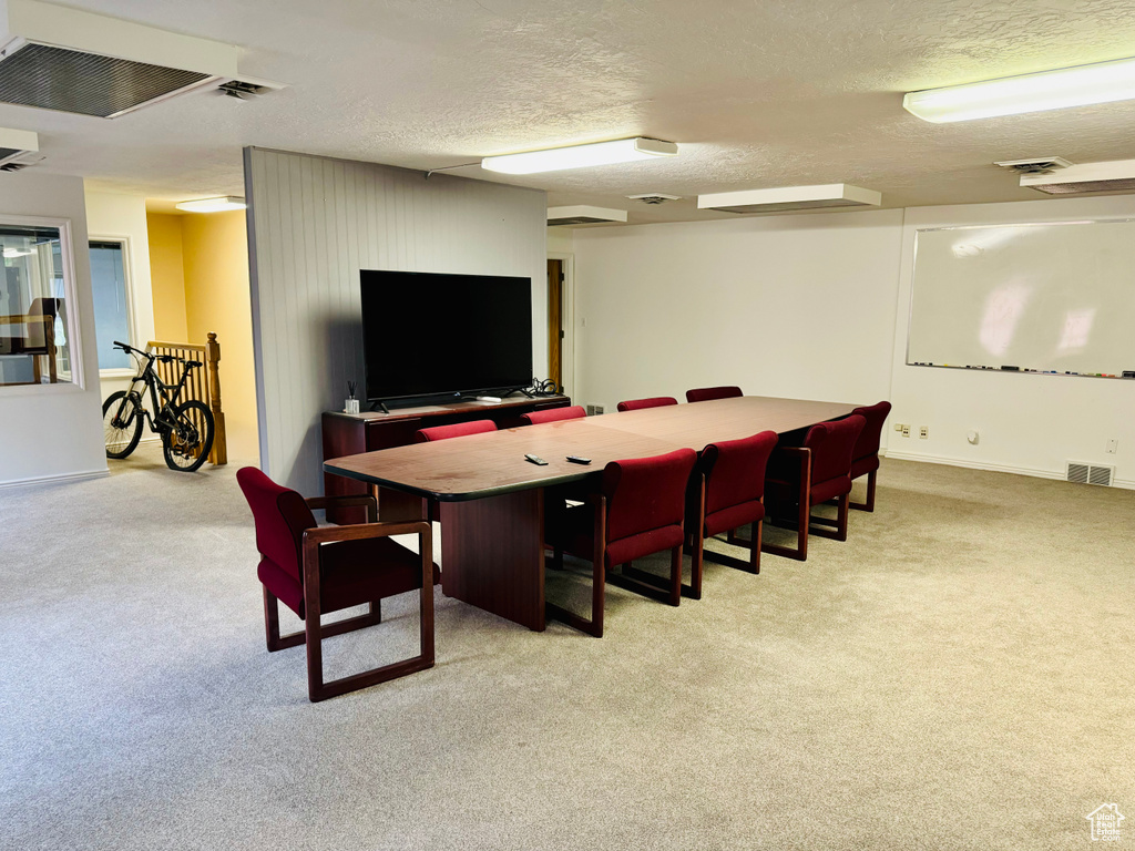 Office area with light carpet, a textured ceiling, and baseboards