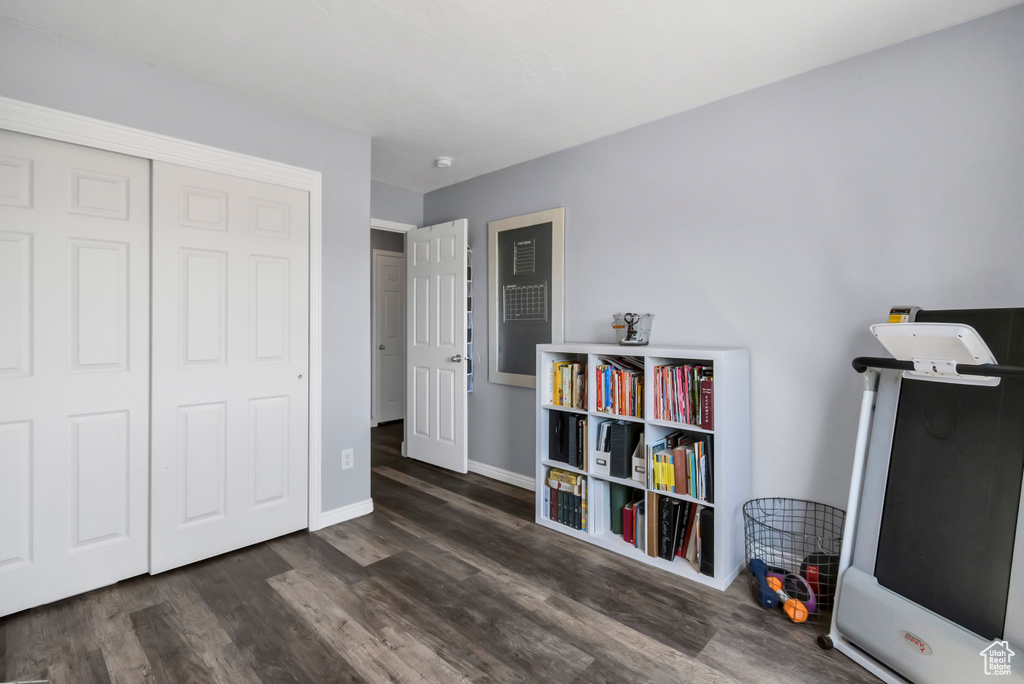 Bedroom featuring wood finished floors, baseboards, and a closet