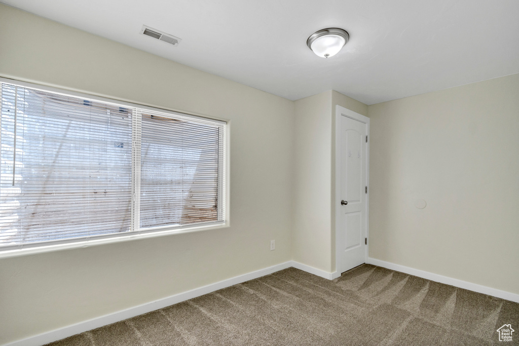 Carpeted spare room with baseboards