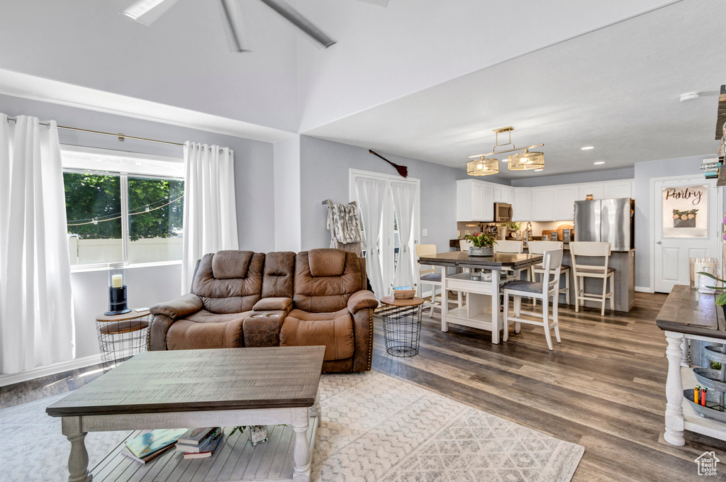 Living area with light wood-style flooring, a ceiling fan, and recessed lighting