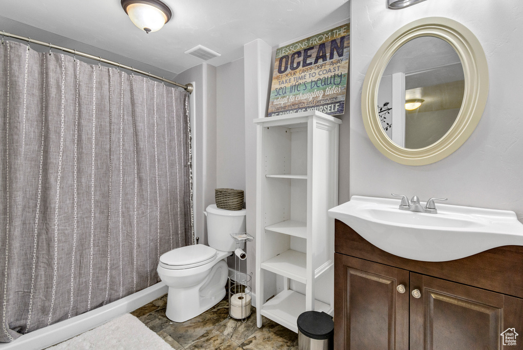 Bathroom with toilet, vanity, and a shower with curtain